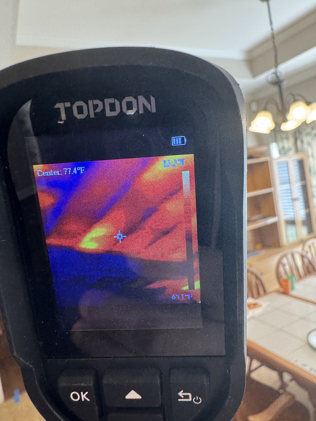 A thermal camera image of a ceiling showing warm orange streaks between cooler blue areas where insulation is thin